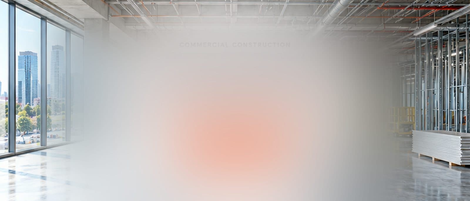 A bright commercial interior mid fit-out, with metal framing and stacked drywall