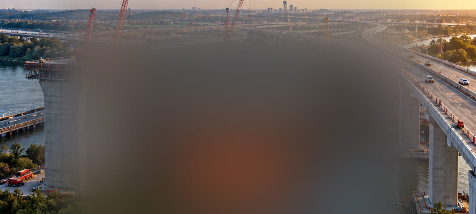 Tower cranes on a highway bridge under construction over a river